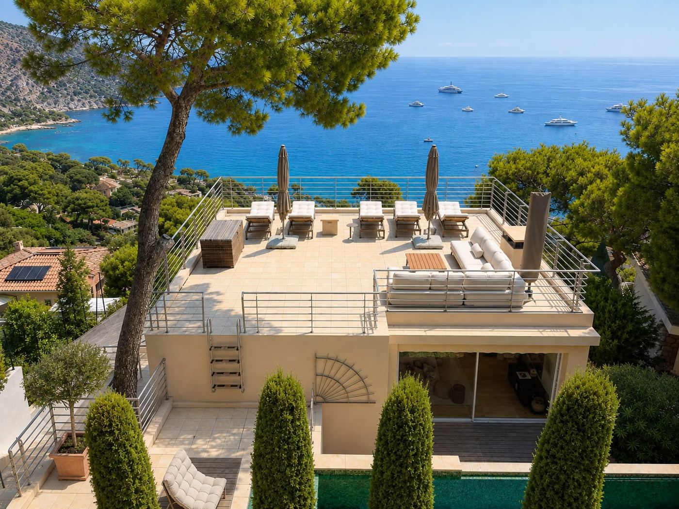 Toit-terrasse avec transats et salon au-dessus de la mer